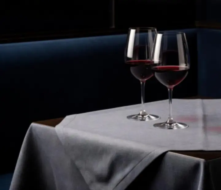 Curated wine bottles and glasses arranged on a dark timber bar